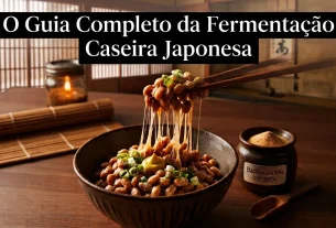 Foto em close de natto tradicional em uma tigela de cerâmica sobre mesa de madeira japonesa. Hashis suspendem os grãos fermentados de soja, revelando filamentos viscosos e translúcidos característicos. Ao fundo rústico, há uma vela acesa e um pote de cultura Bacillus subtilis.