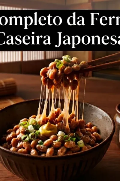 Foto em close de natto tradicional em uma tigela de cerâmica sobre mesa de madeira japonesa. Hashis suspendem os grãos fermentados de soja, revelando filamentos viscosos e translúcidos característicos. Ao fundo rústico, há uma vela acesa e um pote de cultura Bacillus subtilis.